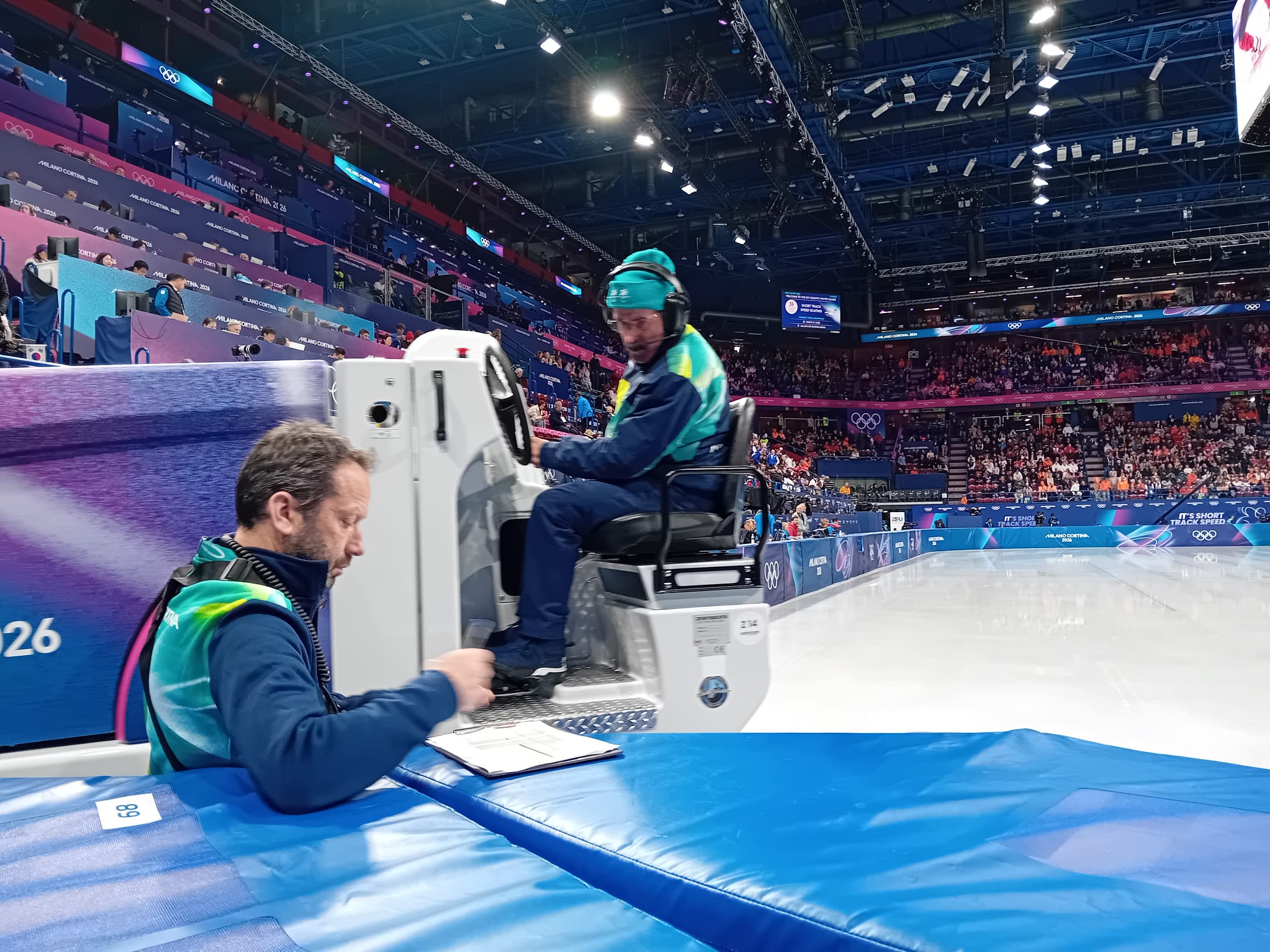 Équipe terrain et surfaceuse au bord de la piste de patinoire